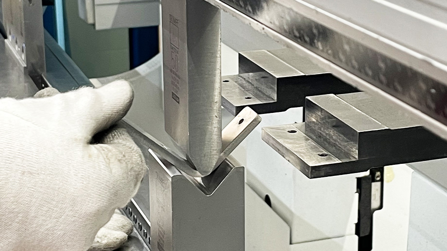 Vedere detaliată: piesa din tablă este îndoită la mașina de îndoit